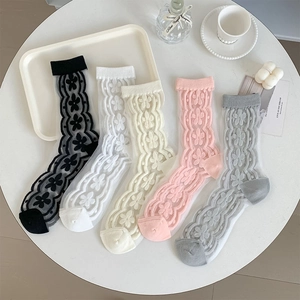 Flat lay of five sheer floral crew socks in assorted pastel colors on a white table