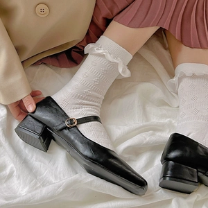 Détail de chaussettes blanches en dentelle avec chaussures Mary Jane noires en style rétro