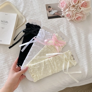 Lace leg warmers with silk bows in four colors shown in a vintage aesthetic setting