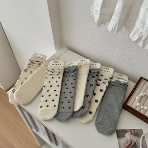 Détails de chaussettes en tricot avec bords en dentelle, nœuds et motifs floraux doux
