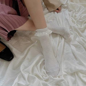Vue détaillée de chaussettes hautes blanches avec dentelle ajourée et bord en ruban