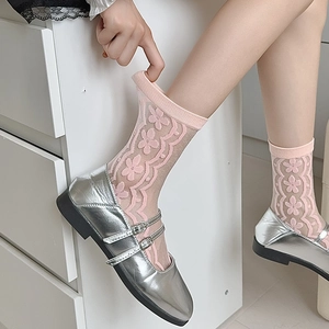 Detailed view of pink floral lace sheer socks paired with silver Mary Jane shoes