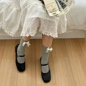 Chaussettes grises mi-mollet avec nœuds en dentelle blanche et bordures à volants
