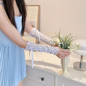 Close-up of white Lolita lace arm sleeves with ruffle edges and cute ribbon bows