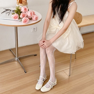 Détail de collants en résille blancs avec motifs nœuds tissés et style Lolita doux