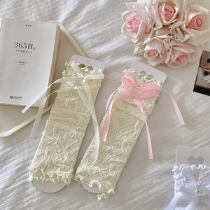 Detailed macro view of Lolita style mesh lace arm sleeves with elegant satin bow accents