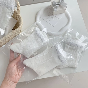 Detail of white lace socks with heart mesh and ruffle trim in premium gift packaging