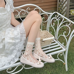 Detail of white lace mid-calf socks with intricate floral patterns and breathable fabric