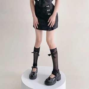 Détail de chaussettes résille Lolita noires avec nœuds en satin et dentelle