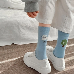 Détail d'une chaussette en coton bleu clair avec broderie lapin et arbre pour femme