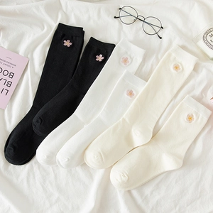 Detailed shot of white and beige socks with cherry blossom embroidery on ribbed cotton