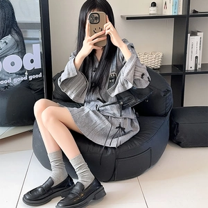 Detail of grey ribbed split-toe mid-tube socks paired with black loafers for a chic look