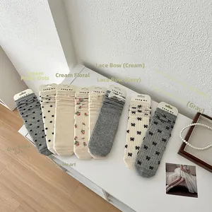 Vue à plat de chaussettes mi-mollet japonaises avec nœuds en dentelle et motifs cœur