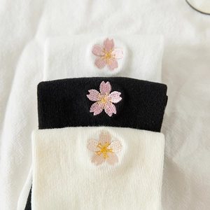 Close-up of cherry blossom embroidery on cotton crew socks in white, black and cream
