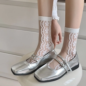 Detail of sheer floral lace socks paired with silver metallic double strap Mary Jane shoes