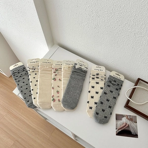 Détails de chaussettes à nœuds et dentelle aux motifs pastels avec étiquettes