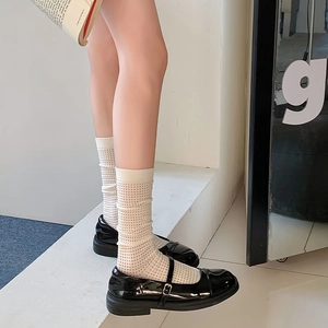Detail of black Mary Jane shoes paired with beige lace mesh Lolita knee high socks