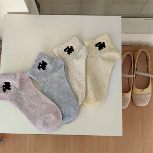 Close-up of four pairs of spotted cotton socks featuring cute cartoon dog embroidery