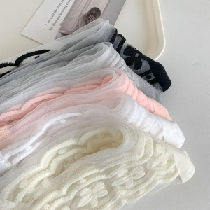 Close-up of stacked sheer glass silk socks with floral lace and jacquard patterns