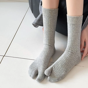 Detail of light gray ribbed tabi socks showing the two-toe split design and cotton texture