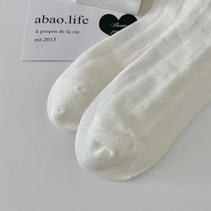 Close-up of white ribbed knit fabric texture on breathable cotton blend socks
