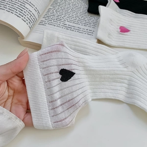 Detail of ribbed knit socks with delicate heart embroidery and vertical striped texture
