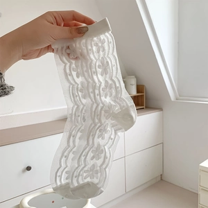 Close-up of white floral lace socks with sheer mesh texture and wavy patterns