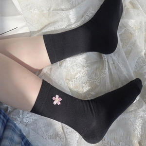 Close-up of black cotton crew socks featuring delicate pink cherry blossom embroidery