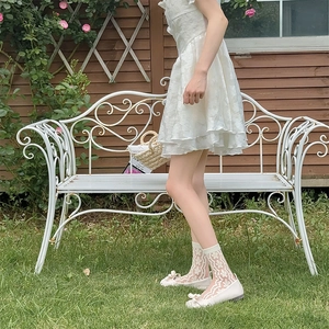 Detailed close-up of white floral lace crew socks paired with elegant ribbon flats
