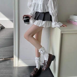 Detail of white Lolita socks with layered bows paired with brown leather loafers
