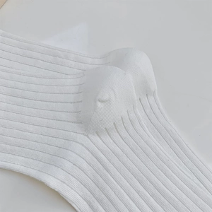 Macro detail of white ribbed knit cotton socks showing premium vertical stripe texture