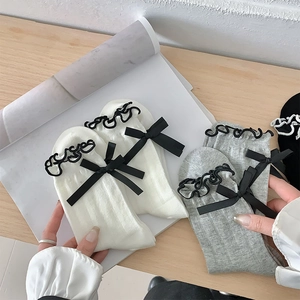 Detail of breathable mesh crew socks featuring elegant black ribbon bows and ruffle edges