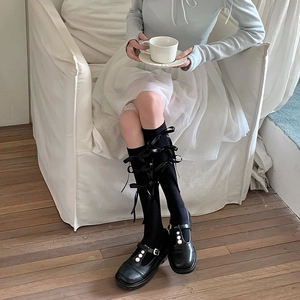 Detail van Lolita kousen met satijnen strikken en Mary Jane schoenen met parelversiering