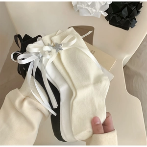 Gros plan de chaussettes avec nœuds en satin et étoiles pailletées de style balletcore