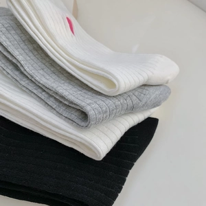 Close-up of ribbed cotton socks with delicate pink heart embroidery and textured finish