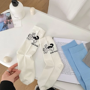 Détail de chaussettes en coton avec motif chat mignon et accessoires de style minimaliste