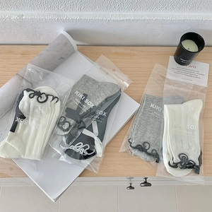 Detail of mesh socks in gift packaging with ribbons and delicate ruffled trim