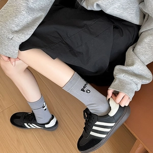 Détail de chaussettes grises avec texte panda, empreinte de patte et bords côtelés