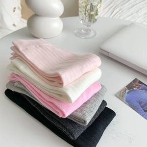 Vertical ribbed split-toe socks in multiple colors shown with minimalist home decor items