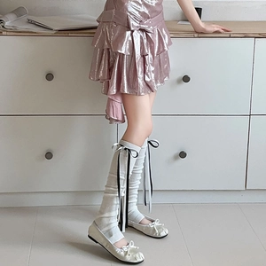 Détails de jambières tricotées roses avec des rubans noirs et blancs de style ballet