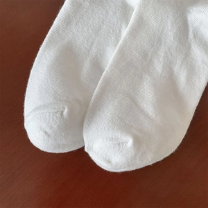 Gedetailleerde macro-opname van witte katoenen sokken met focus op de teennaad en weving