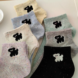 Flat lay of colorful speckled knit socks with cute puppy embroidery detail