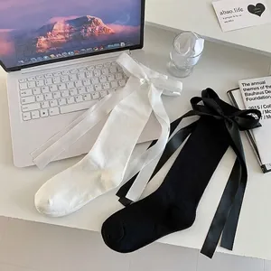 Japanese style knee-high socks featuring large satin bows in black and white colors