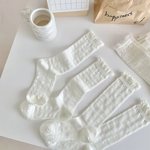 Flat lay of white Lolita lace socks with heart patterns and ruffle edges for women