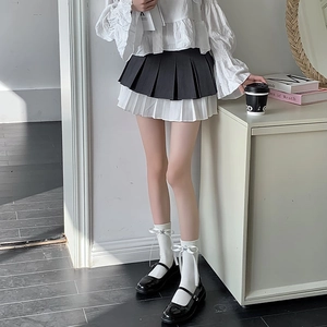 Détail de chaussettes blanches style ballet avec nœud et étoiles et souliers noirs