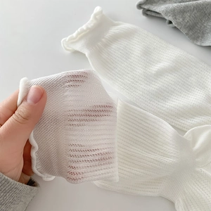 Macro detail of breathable white mesh socks showing the sheer ribbed texture and stretch