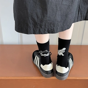 Détail de chaussettes noires avec broderie mignonne de chien et d'os sur le talon