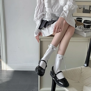 Détail de chaussettes blanches Lolita avec nœuds et chaussures Mary Jane noires JK