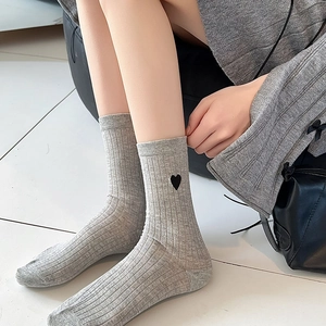 Detail of light gray ribbed crew socks with black heart embroidery for women