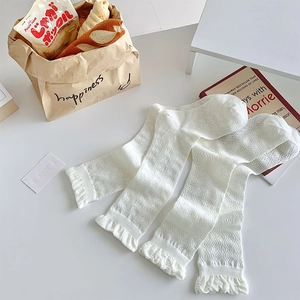Close-up of white lace crew socks with hollow heart patterns and ruffled cuffs
